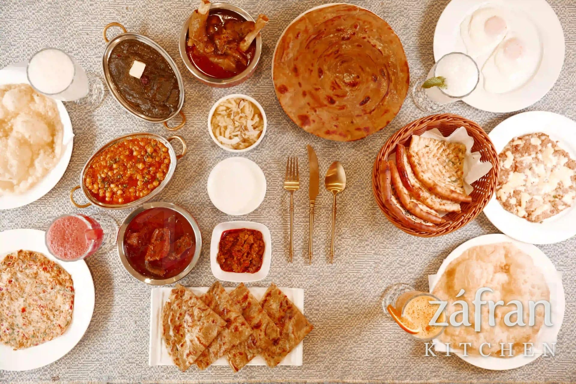 A full nashta spread of halwa puri, channa, paya, nihari, paratha and chai at Zafran Kitchen Ajman