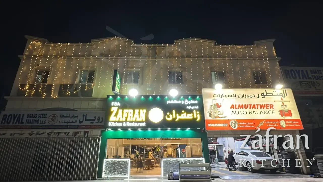 The lit Zafran Kitchen and Restaurant shopfront at night on Amman Street, Ajman Industrial Area 2
